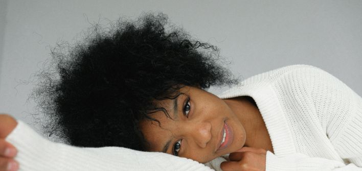 Romantic young black woman leaning on table