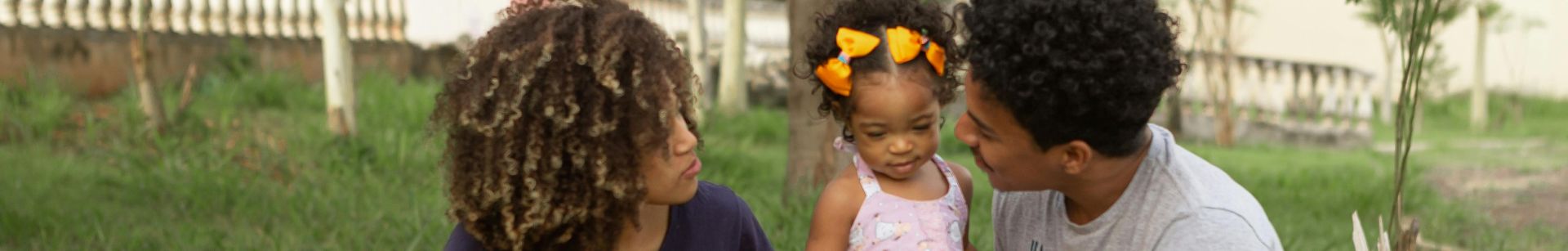 Black family spending weekend on meadow in urban park